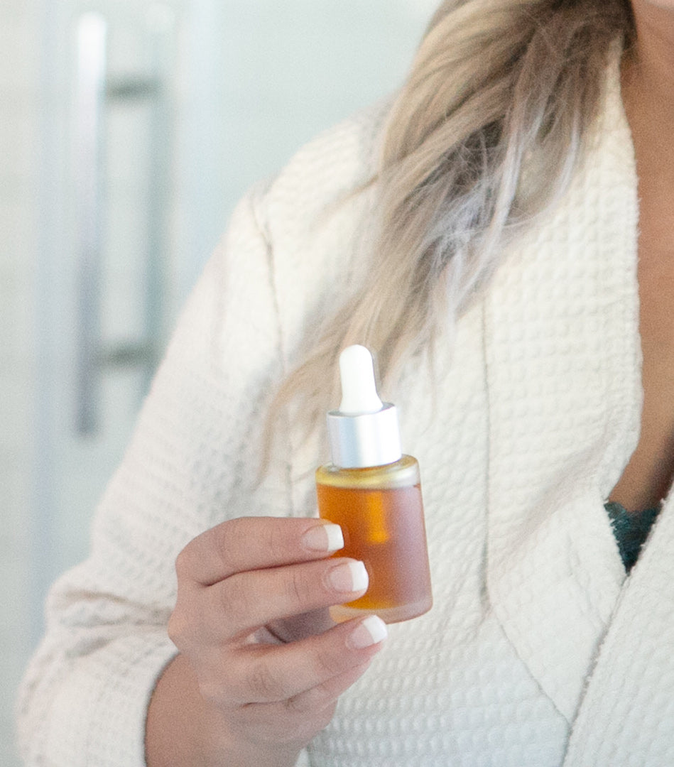 woman holding dropper bottle